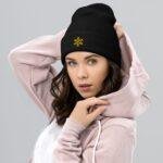 Išsiuvinėta žieminė kepurė su snaigės simboliu. Šilta, kalėdinio dizaino, anti-alerginė kepurė, yra universalaus stiliaus, todėl tai gali būti puiki dovana